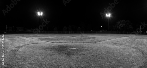 Panorama of empty baseball field at night from behind home pate photo