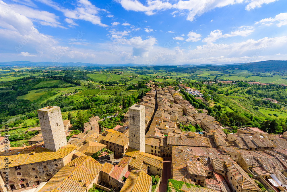 Aerial view of the historic town of San Gimignano with beautiful landscape scenery on a sunny summer day in Tuscany, small walled medieval hill town with towers in the province of Siena, Italy
