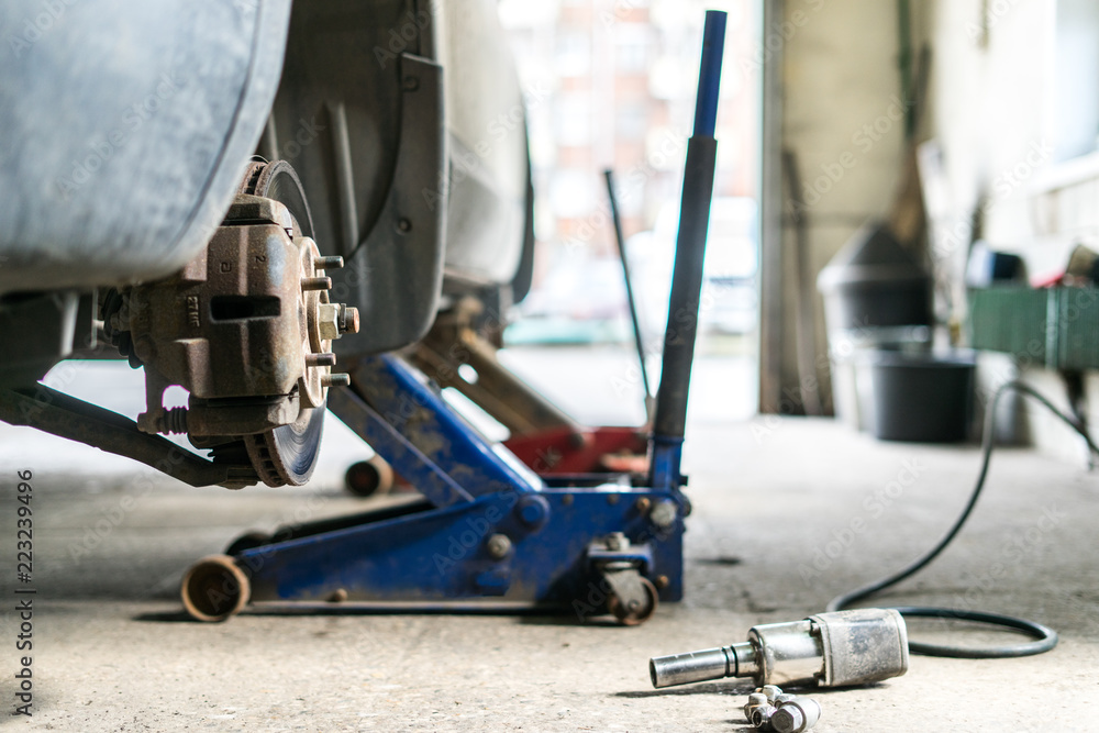 Fototapeta premium Closeup detail of the wheel assembly on a modern automobile. The rim is removed showing the front rotor and caliper.