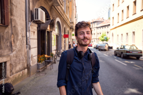 Portrait of cheerful young man waiting on the street