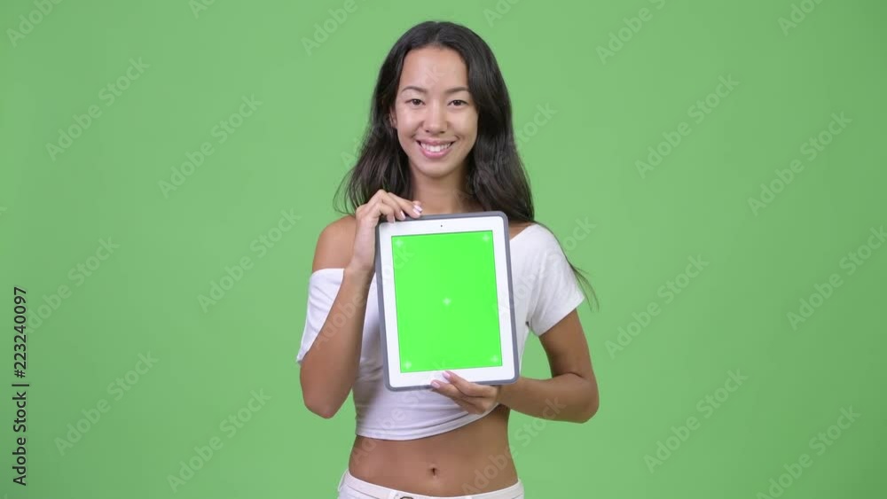 Young happy beautiful multi-ethnic woman showing digital tablet Young happy beautiful multi-ethnic woman showing digital tablet