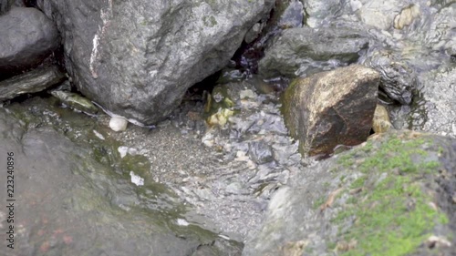 Water running from waterfall to the fjord between rocks photo