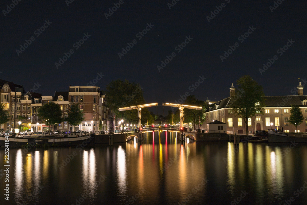 アムステルダムの夜の運河に光る橋