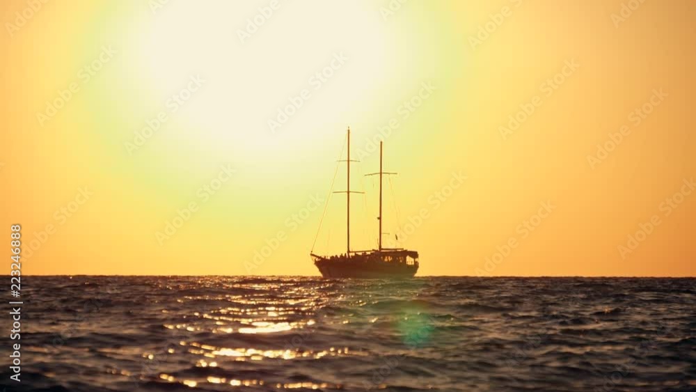 Sailing yacht in the open sea at sunset, rocking on the waves