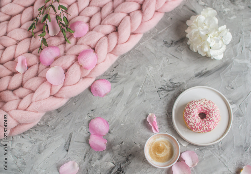 Cup with cappuccino, doughnut, pink pastel giant blanket, flowers, bedroom, morning concept Cup with cappuccino, doughnut, pink pastel giant blanket, flowers, bedroom, morning concept