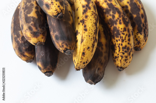 Stacked bunch of overripe baby bananas isolated on white, copy space, horizontal aspect