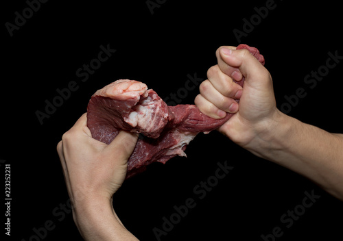 Fresh meat in a hand on a black background