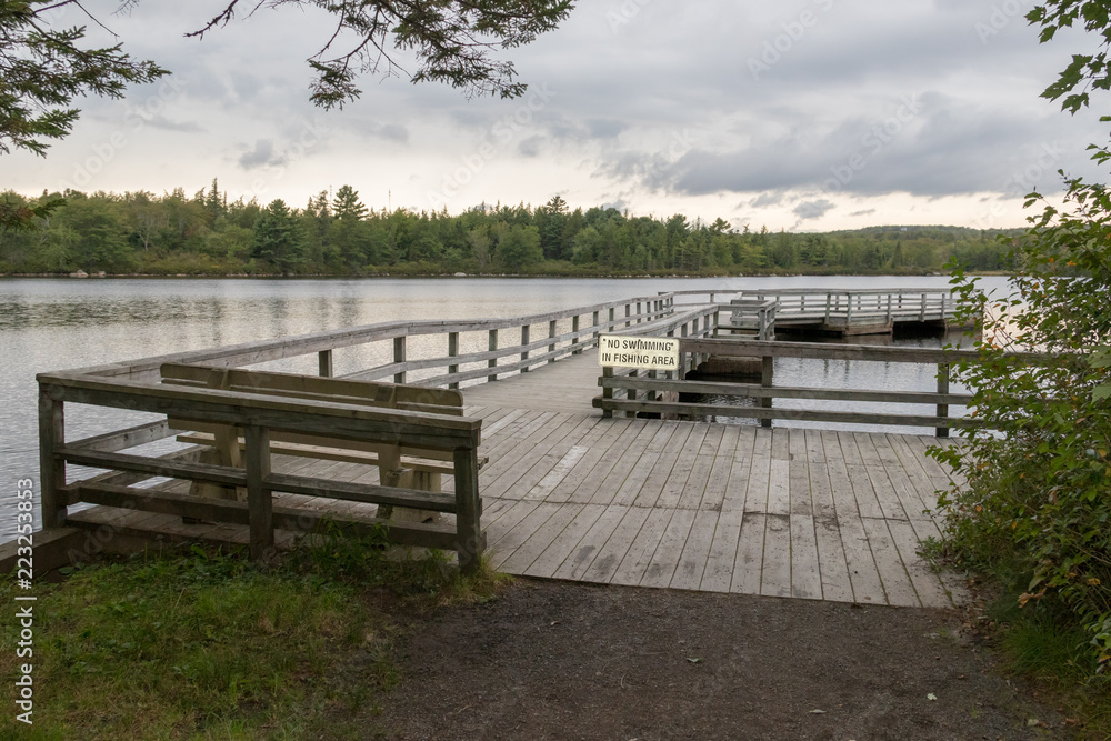 Wooden boardwalk lakeside, overcast sky, lewis lake, nova scotia, canada