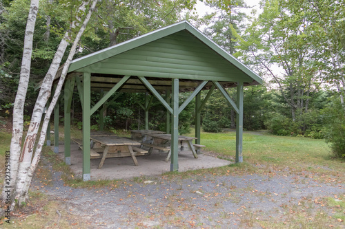 Green wooden shelter with picnic tables, overcast day, lewis lake, nova scotia, canada