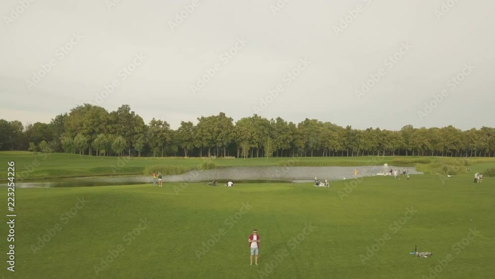 Young man navigating a flying drone with remote control. Man in countryside flying drone and taking pictures Young man navigating a flying drone with remote control. Man in countryside flying drone and taking pictures