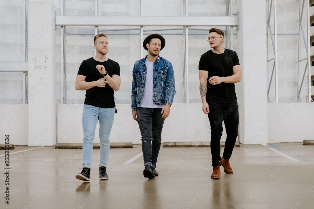 Fototapeta premium Group of Young Hipster Men Modeling in Downtown Urban Parking Landscape