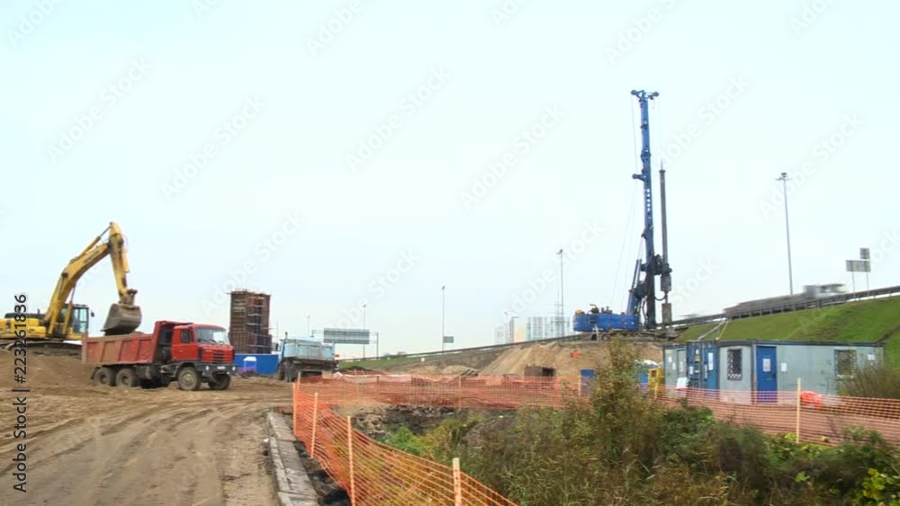 Construction of a new road outside the city limits. Trucks and excavator at the construction site Construction of a new road outside the city limits. Trucks and excavator at the construction site