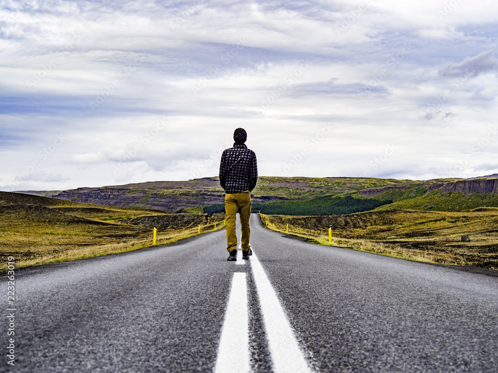Traveler walking into the horizon on the Ring Road of Iceland enjoying the scenery