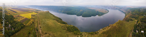 Panorama of big river canyon, village and rural fields