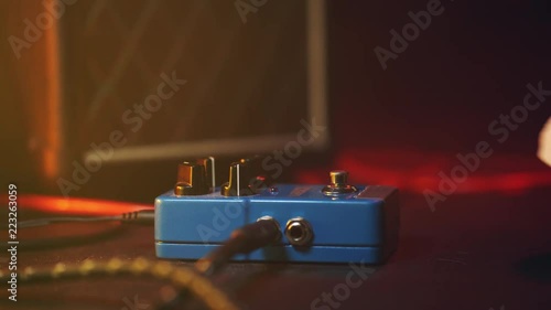 Close up of guitar player foot pressing pedal. Musician uses music effect loop machine. Man in trendy sneakers, his foot playing at stage during concert. Macro view. photo