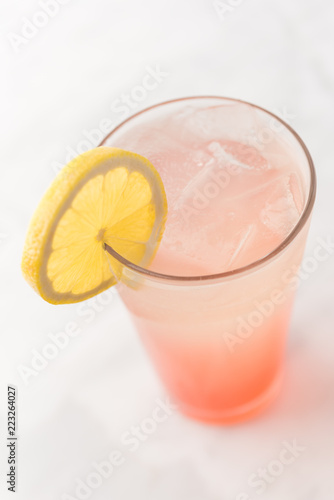 Pink strawberry lemonade in glass with green straw