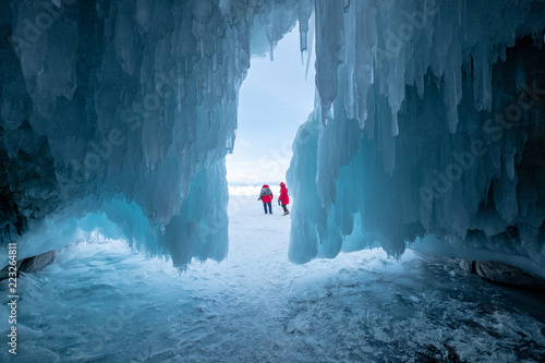 Two women outside an icicle covered cave, Irkutsk Oblast, Siberia, Russia