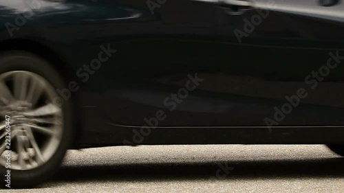 Duck and ducklings quickly crossing a street with cars passing by photo