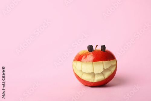 Funny smiling apple on color background. Space for text