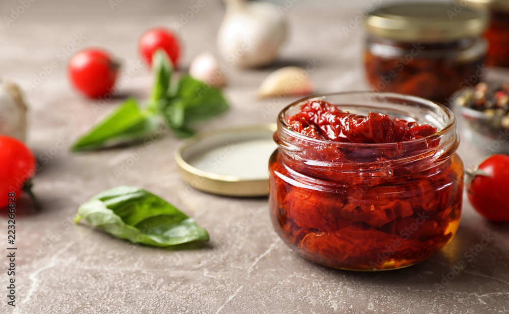 Dried tomatoes in glass jar on table. Healthy snack - obrazy, fototapety, plakaty 