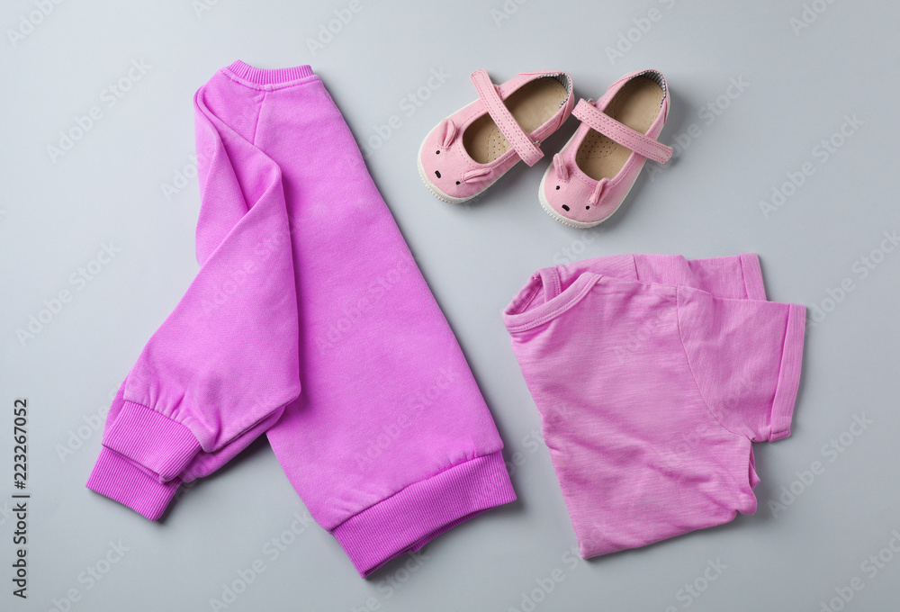 Flat lay composition with cute child clothes and shoes on color background Flat lay composition with cute child clothes and shoes on color background