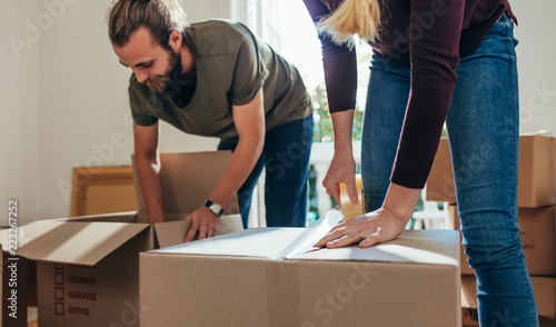 Couple working together in packing their household items in boxe