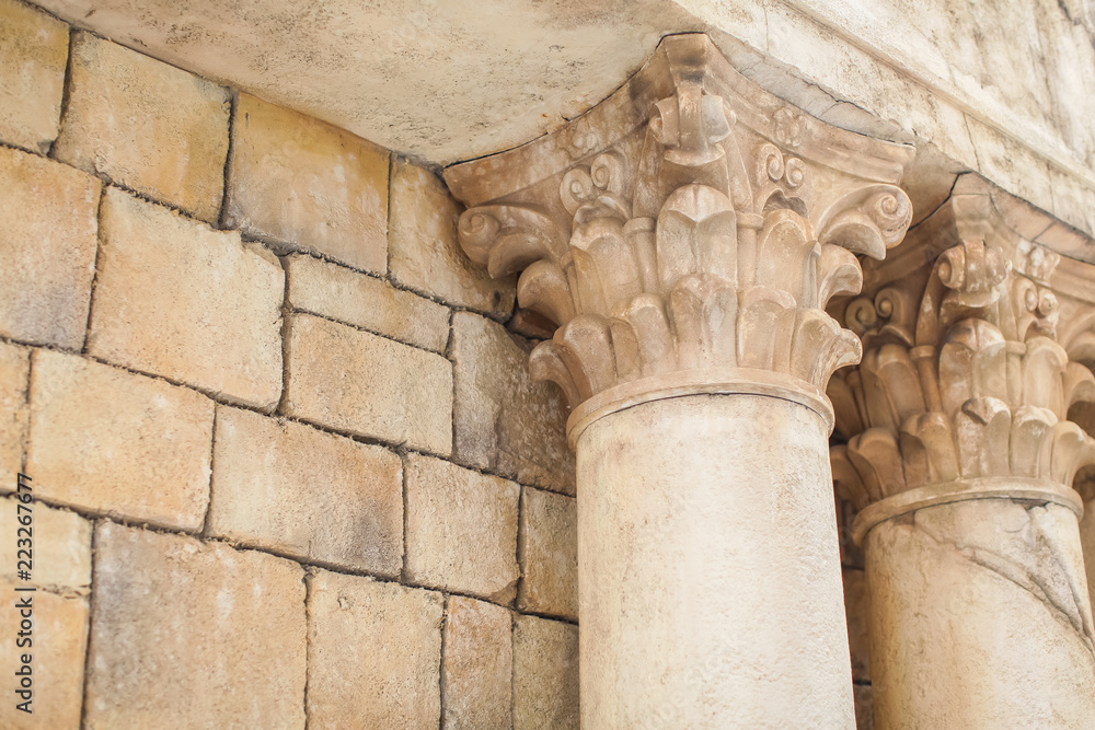 shot of imitation line of Greek-style columns sand color with cracks and old dust