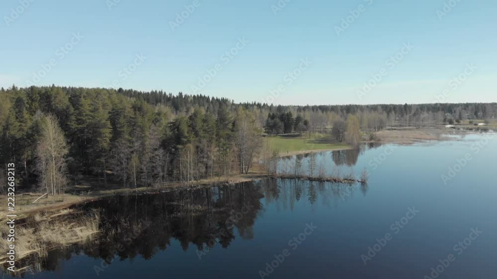 Flight to a wooded area located on the shore of a peaceful lake Flight to a wooded area located on the shore of a peaceful lake