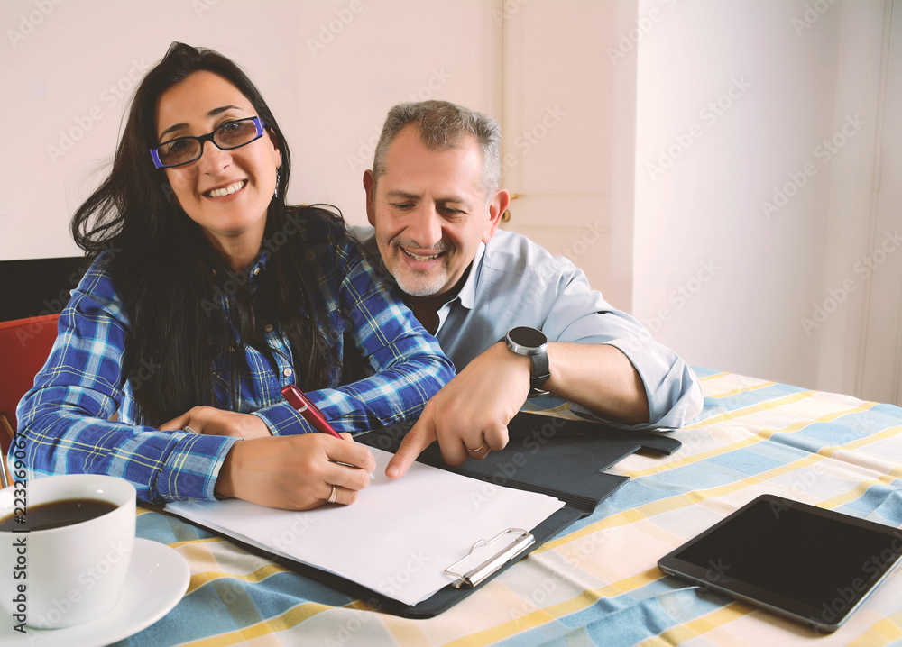 Middle-aged couple working together from home Middle-aged couple working together from home