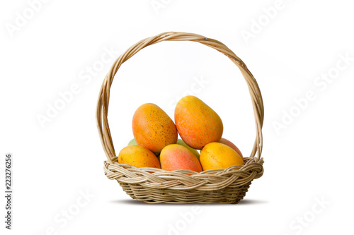 Mango tropical fruit in wooden basket isolated white background
