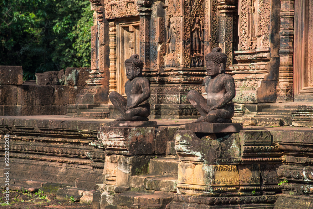 The guardian sculpture in front of the main buildings of Banteay Srei the beautiful pink sandstone temple in Siem Reap, Cambodia.