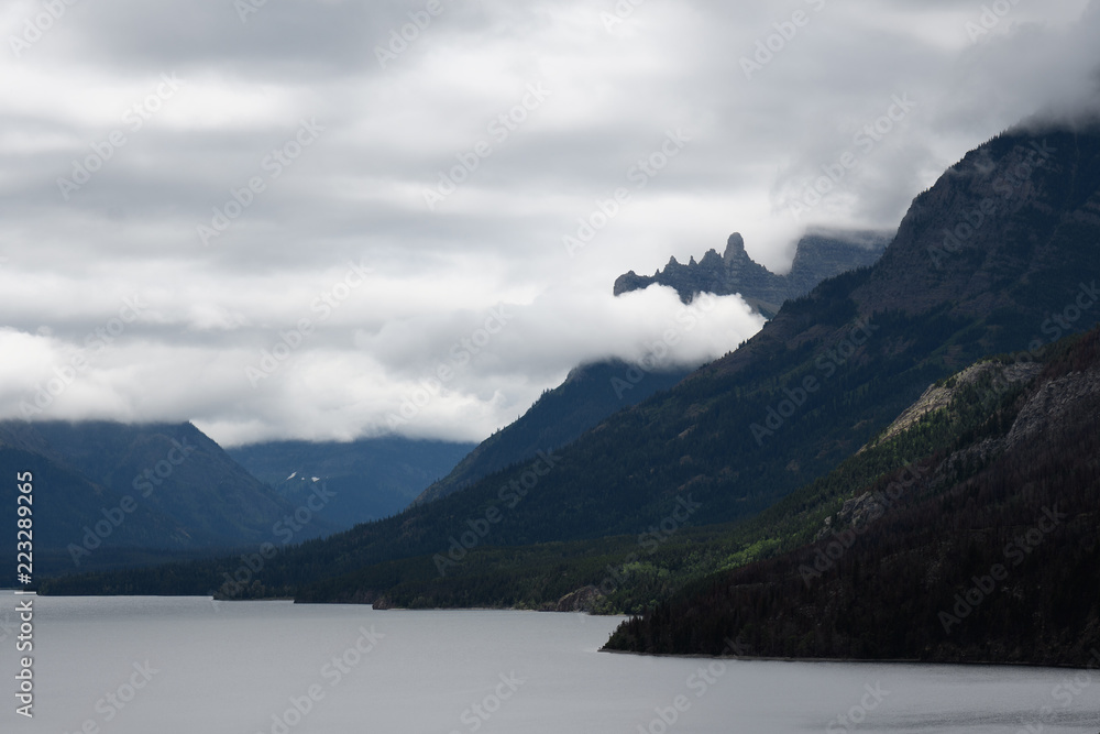 Misty clouds rise over Upper Waterton Lake mountain peaks in Waterton Lakes National Park, Canada