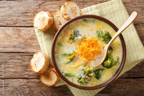 Healthy lunch broccoli cheese soup in a bowl with toast close-up. Horizontal top view