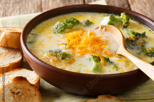 Freshly cooked broccoli cheese soup in a bowl with toast close-up. horizontal