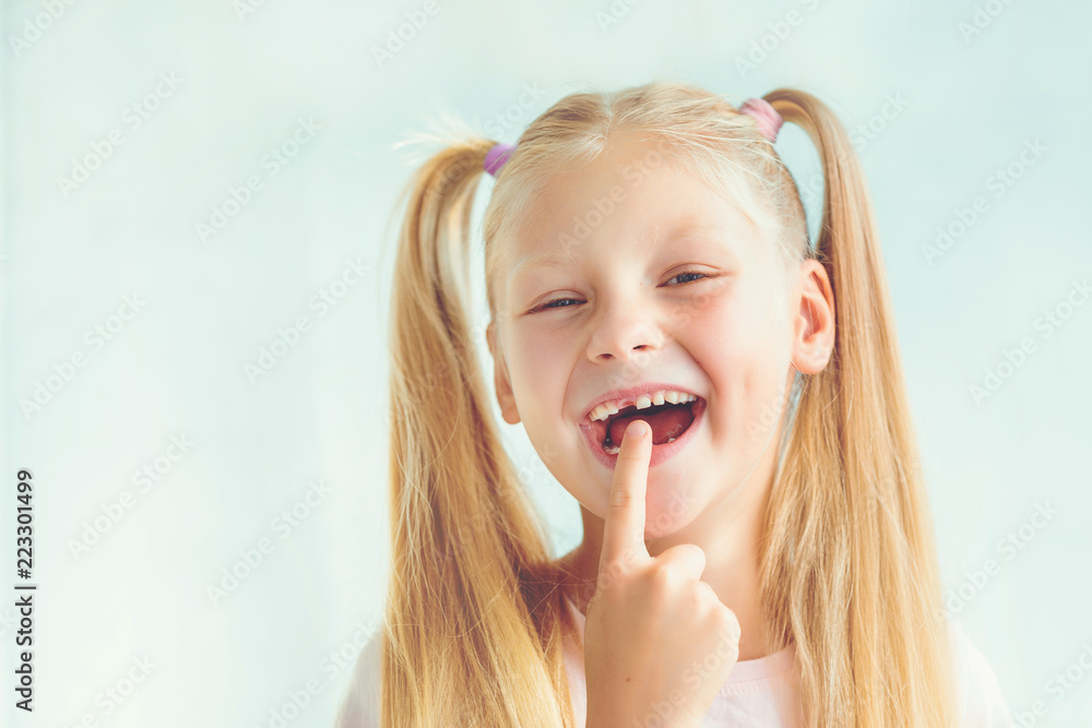 Portrait of a smiling little girl after dropping her front baby tooth Portrait of a smiling little girl after dropping her front baby tooth