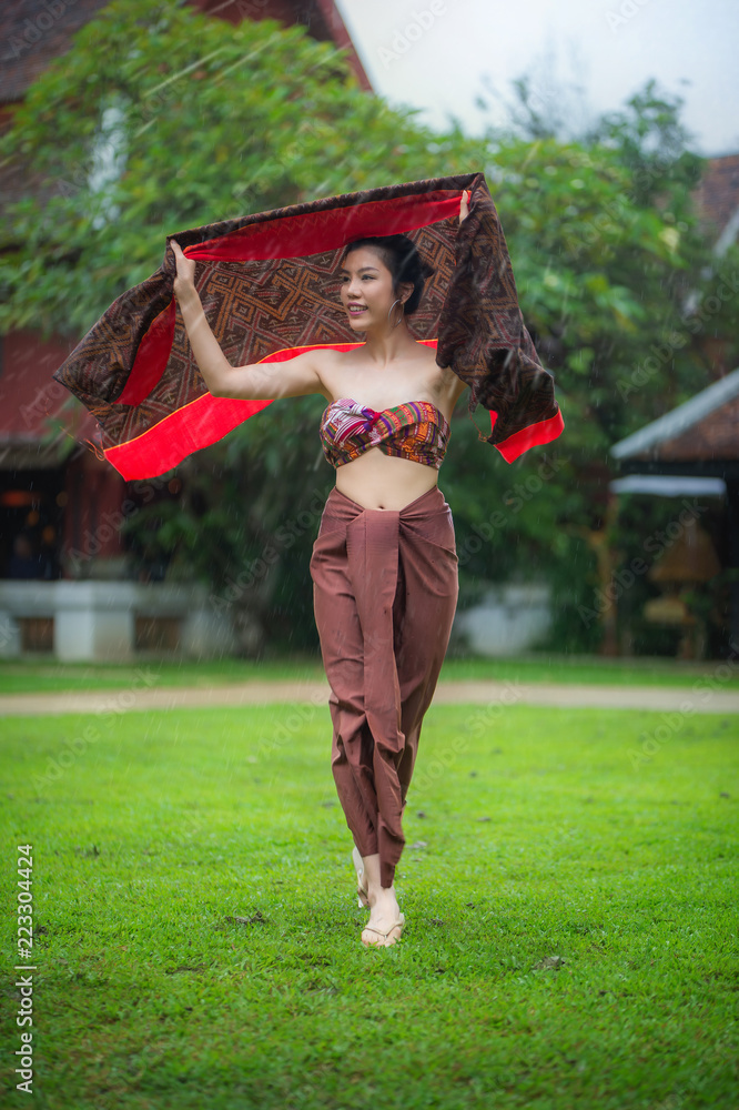 Thai Woman in Traditional Thai Dress running while raining