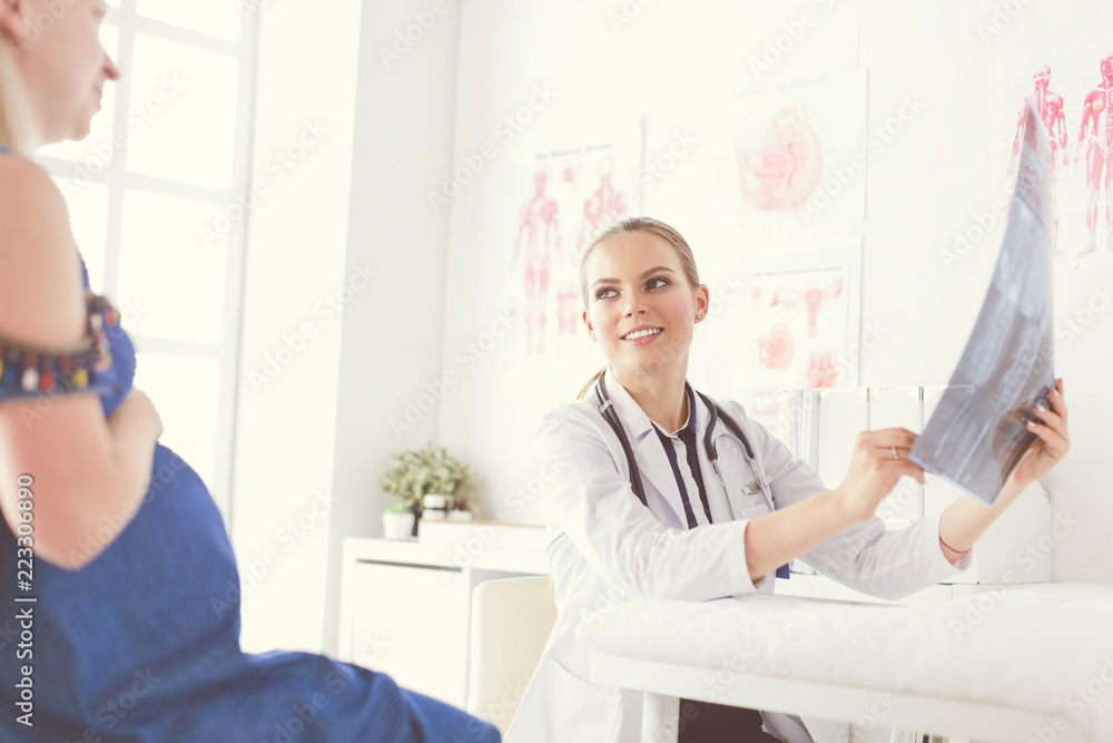 Obraz premium Young attractive female doctor looking at x-ray image