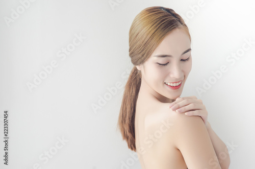 Pretty girl with nude make up and naked shoulders posing at background, beauty photo concept, skin care