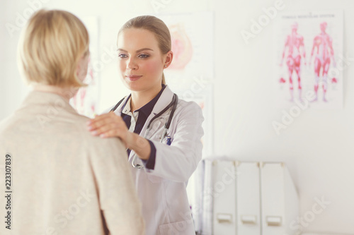 Doctor and patient discussing something while sitting at the table . Medicine and health care concept