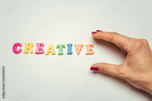 Creative concept, word in colorful plastic letters on white background photo