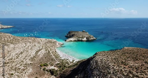 Aerial view of Isola dei Conigli next to the island of Lampedusa, Sicily, Italy with Mediterranean sea. Italian summer landscape seen from the sky with drone flying over beach photo