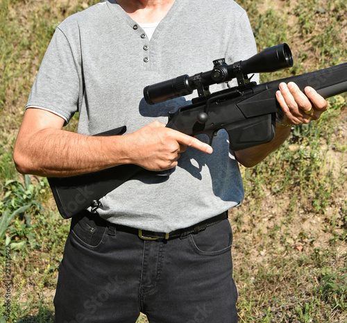 Man stands in hand with a large shotgun