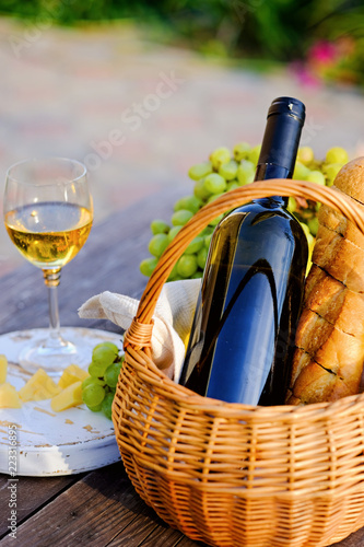 Fototapeta Naklejka Na Ścianę i Meble -  Bottle of wine on a table, summer outdoors. Picnic concept.