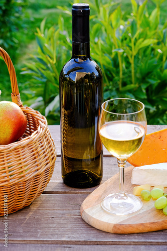 Fototapeta Naklejka Na Ścianę i Meble -  Bottle of wine on a table, summer outdoors. Picnic concept.