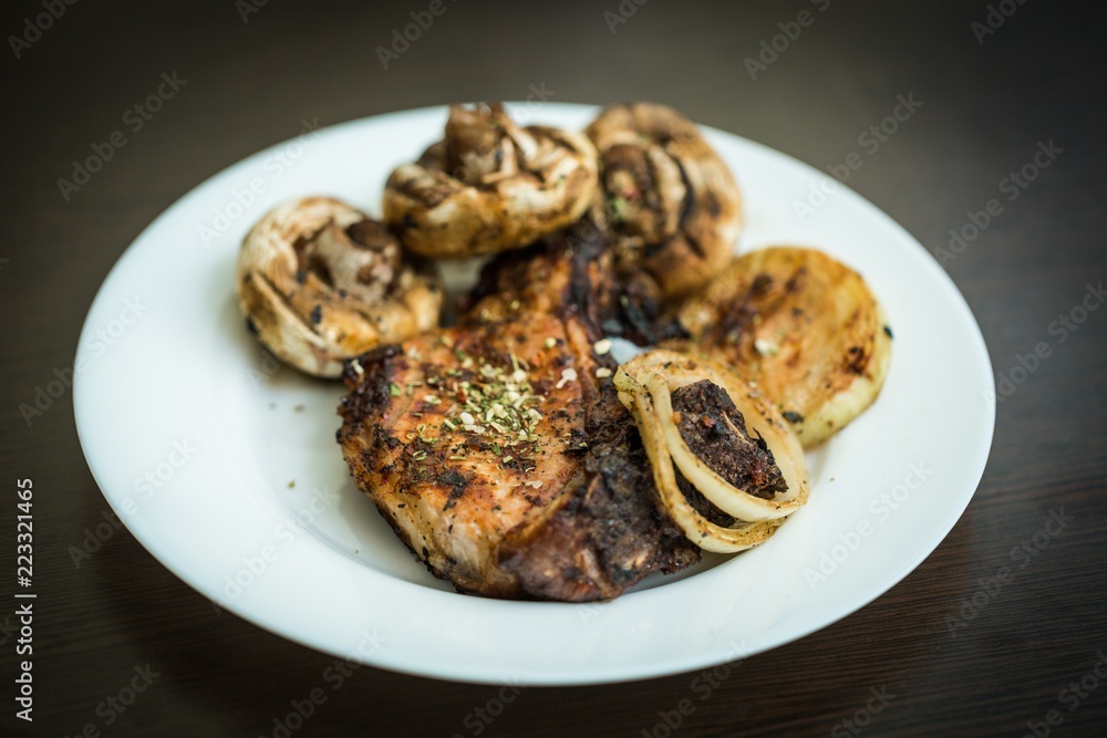 Grilled Steak, Mushrooms and Onion on the Plate on the Black Grilled Steak, Mushrooms and Onion on the Plate on the Black