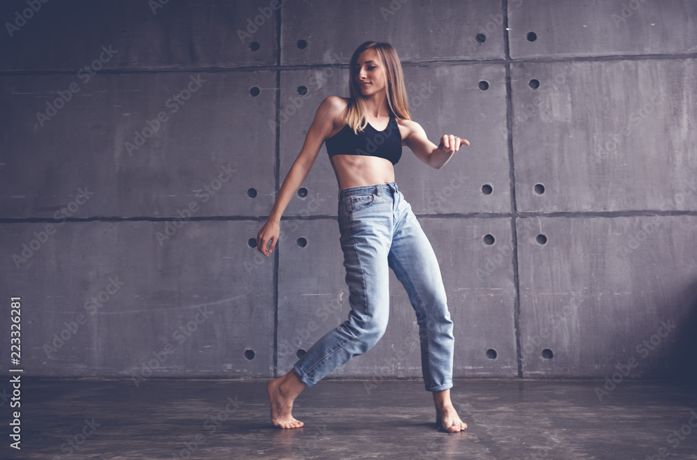 young beautiful woman in top and jeans dancing modern contemporary dance in the studio, contemporary art, harmony of body and soul, professional dancer young beautiful woman in top and jeans dancing modern contemporary dance in the studio, contemporary art, harmony of body and soul, professional dancer