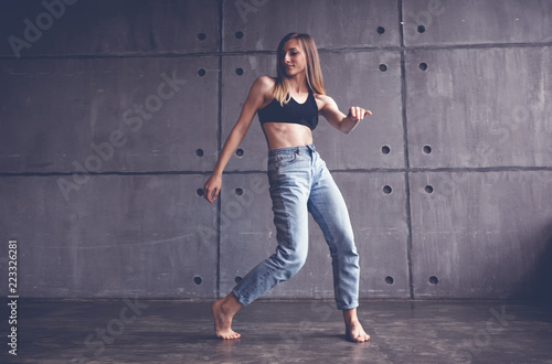young beautiful woman in top and jeans dancing modern contemporary dance in the studio, contemporary art, harmony of body and soul, professional dancer
