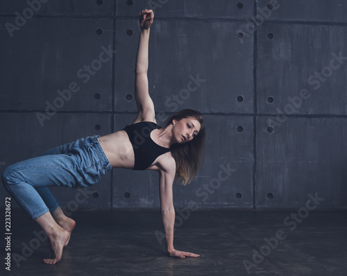 young beautiful woman in top and jeans dancing modern contemporary dance in the studio, contemporary art, harmony of body and soul, professional dancer