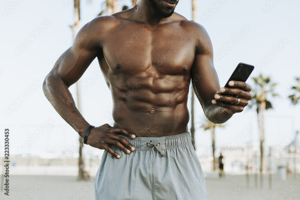 Obraz premium Fit man listening to music while at the beach