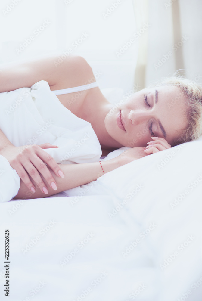 Pretty woman lying down on her bed at home